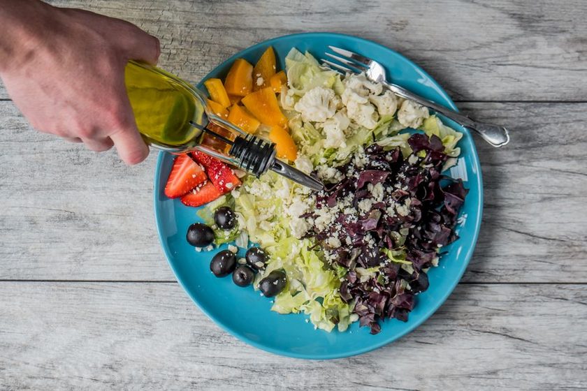 Colorful vegetables, berries, olive oil and nuts arranged on a table